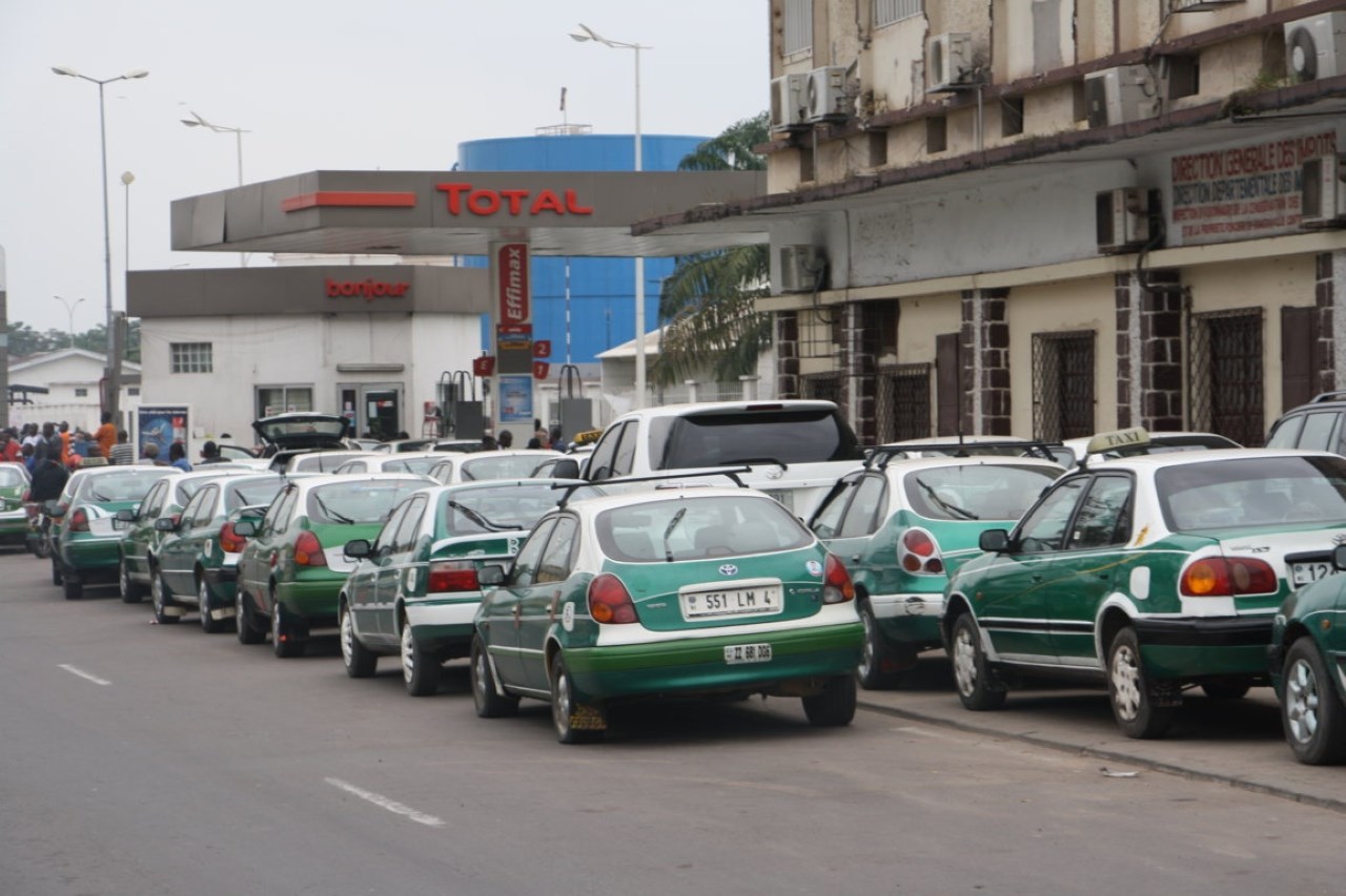 File d'attente de véhicules devant une station-service au Congo, illustrant les pénuries de carburant.