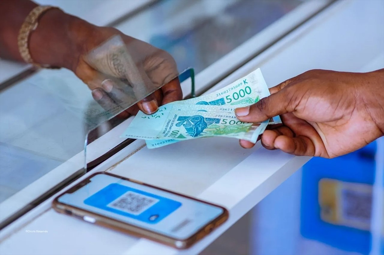 Un commerçant acceptant des paiements mobiles avec plusieurs autocollants de portefeuilles mobiles.